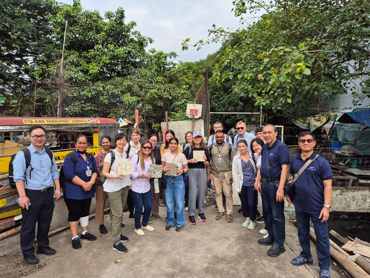 A group of people from the Asian Development Bank visit Buhangin Creek in Manila, standing together outdoors.