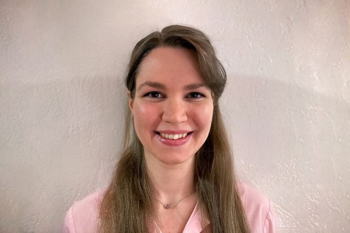 Potrettikuva vaaleanpunaiseen puseroon pukeutuneesta Susanna Haapasesta. Taustalla on vaalea seinä.