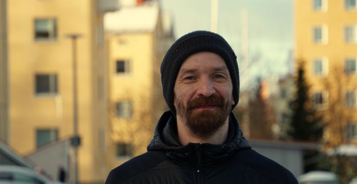 Petteri Huttunen seisoo ulkona, taustalla on kerrostaloja.