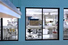 Laboratorio, jossa on lasiseinä ja henkilö työskentelee tietokoneen ääressä.