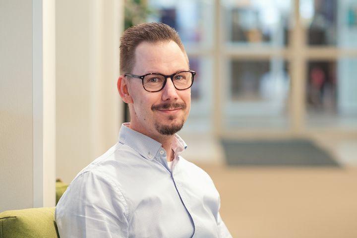 Henri Kervola katsoo kameraan, taustalla toimistoympäristöä.