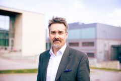 Harri Nieminen seisoo ulkona Hervannan kampuksella ja katsoo kameraan.