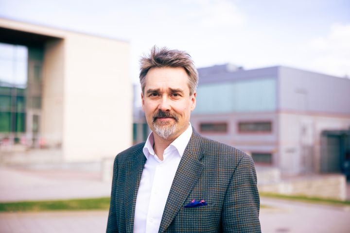 Harri Nieminen seisoo ulkona Hervannan kampuksella ja katsoo kameraan.