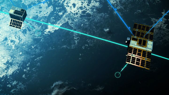 Kaksi satelliittia avaruudessa, yhdistyneenä laserin kaltaisilla valoilla. Taustalla näkyy maapallon pinta.