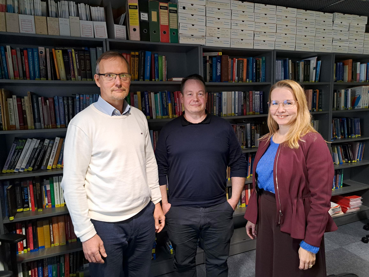 Corelabin johtoryhmän jäsenet Jukka Puhto, Antti Kurvinen ja Jenni Poutanen kirjahyllyjen edessä.
