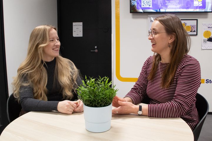 Insinööriopiskelijat Enni Ohrankämmen ja Tiia Töyrylä juttelevat pyöreän pöydän ääressä.