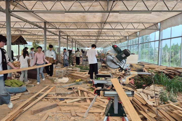 Opiskelijat kantavat jätelautoja.