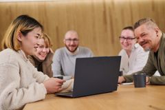 Aikuisopiskelijoita pöydän ja tietokoneen ääressä.