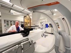 Lääkäri Janne Korhonen seisoo leikkaussalissa pöydän takana.