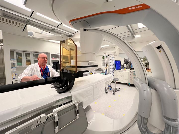 Lääkäri Janne Korhonen seisoo leikkaussalissa pöydän takana.