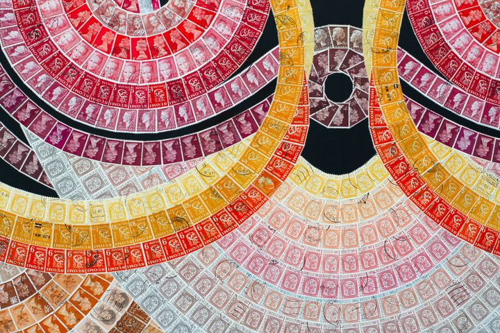 Eri värisiä postimerkkejä aseteltuna kuvion muotoon.