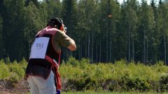 Mies ampumassa savikiekkoa haulikolla