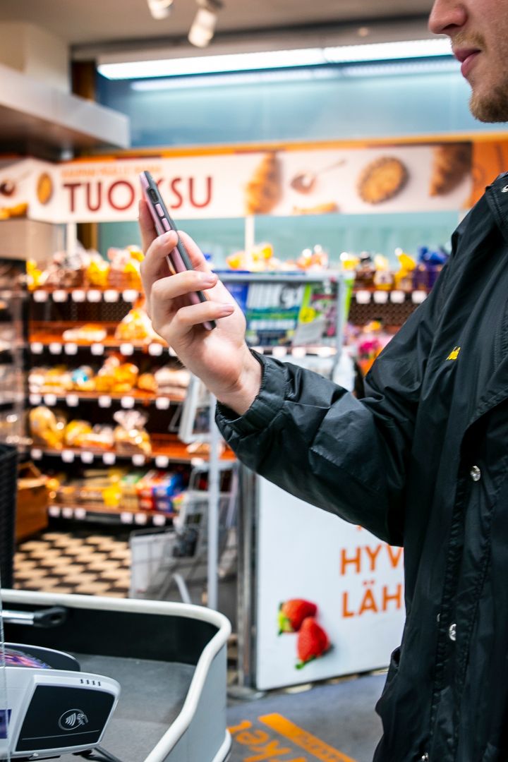 Nuori mies tutkii opiskelijaetuja kaupassa