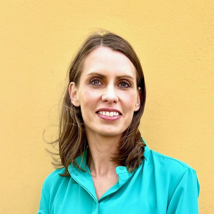 Smiling, dark-haired woman with a turqoise shirt