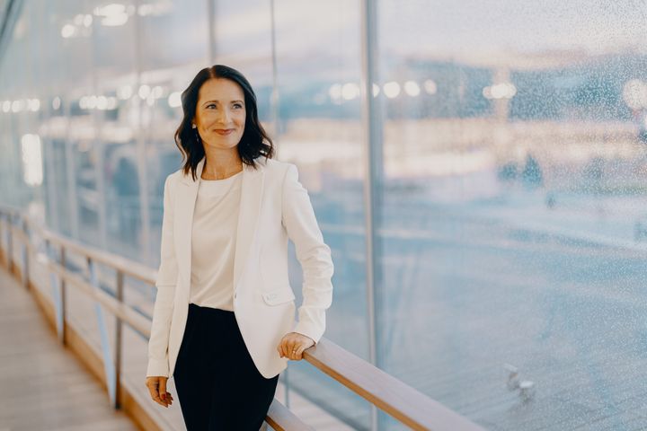 A woman, Tesi's CEO Pia Santavirta, leaning on a railing and posing for the camera