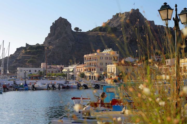 Kuva satamasta, jossa on veneitä ja rakennuksia vuoren juurella Limnoksen saarella.