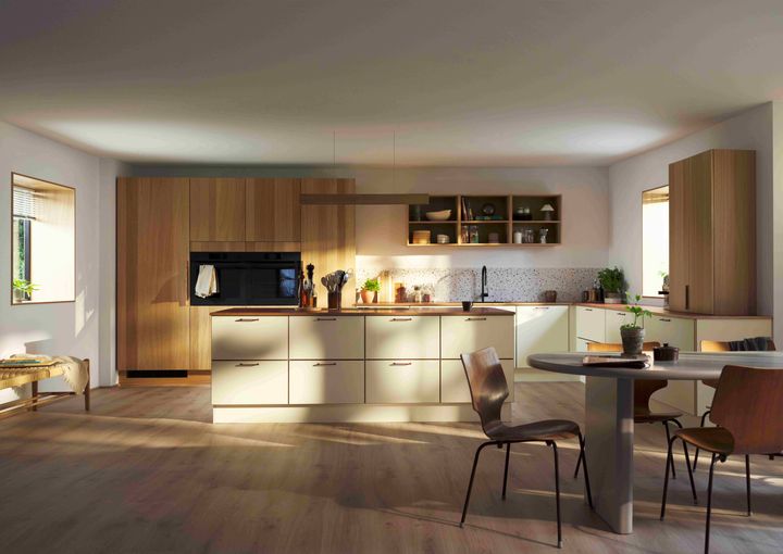 Valoisa, moderni keittiö, jossa on puukaapit ja saareke keskiössä.