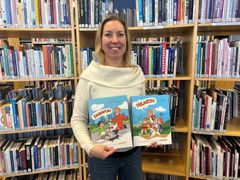 Kirjailija Pirjo Ilmasti käsissään kirjat Pelasta! – Lasten pelastamistaidot tutuiksi riimitellen ja Ensiapua! – Lasten ensiaputaidot tutuiksi riimitellen.