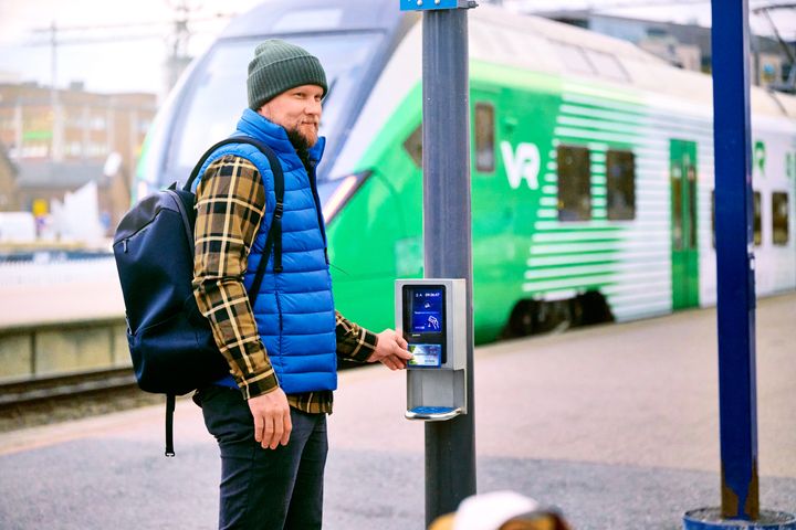 Matkustaja näyttää matkakortin lipunlukijalle ennen matkaa alueellisessa raideliikenteessä Tampereella