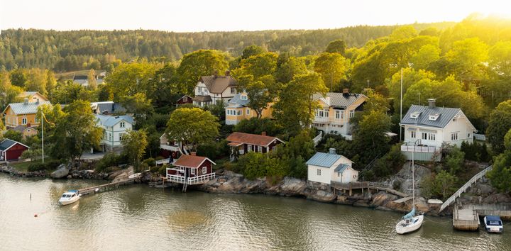 Omakotitaloalue, puita ja laituri veden äärellä Suomessa.