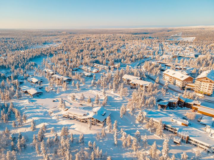 Taivasta, tuntureita ja taloja aurinkoisessa ja lumisessa talvimaisemassa