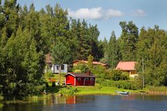 Vehreitä puita ja muutama talo järven rannalla
