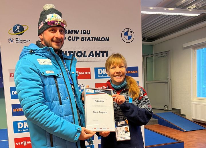 Bulgarian maajoukkue sai ensimmäisenä joukkueiden vastuullisuuspalkinnon, joka lanseerattiin vuoden 2022 maailmancup-tapahtumassa Kontiolahdella. Kunniakirjan äärellä päävalmentaja Krasimir Dochev ja tapahtuman vastuullisuuspäällikkö Sari Jormanainen.