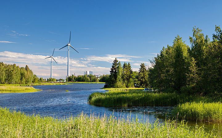 Tuulivoimaloita järvimaisemassa.