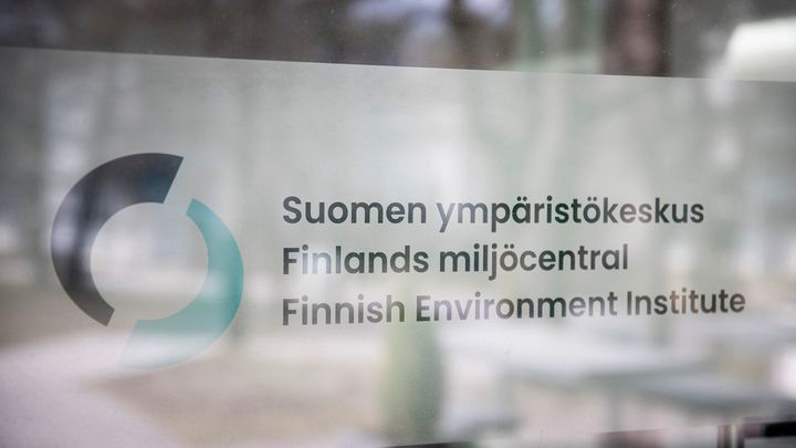 Suomen ympäristökeskuksen nimikyltti toimitilojen ovessa.