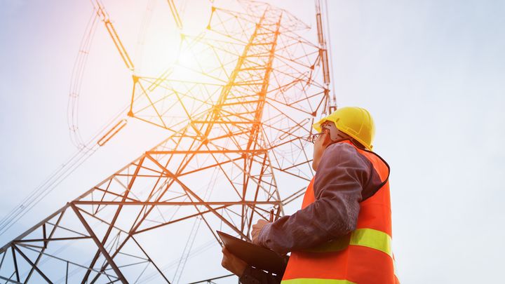 Mies huomioliiveissä korkeajännitetornin alla