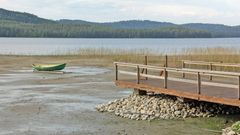 Laituri ja vene ovat jääneet kuivalle maalle, kun vedenpinta on laskenut huomattavasti.