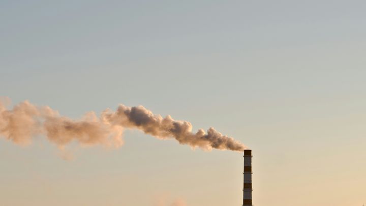 Kuvassa näkyy teollisuuden savupiippu ja taivasta.