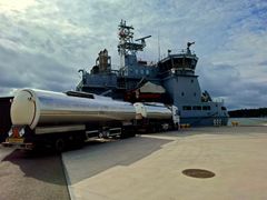 A tanker truck is parked on the quay next to the Finnish Navy's multi-purpose vessel Louhi.