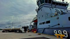 A tanker truck is parked on the quay next to the Finnish Navy's multi-purpose vessel Louhi.
