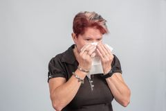 Nainen niistää nenäliinaan.