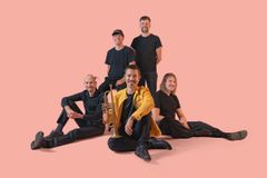 Ilkka Arola Sound Tagine -yhtyeen muusikot poseeraavat vaaleanpunaista taustaa vasten.