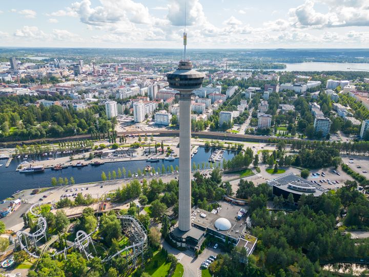 Näsinneula Tampereella kauniina aurinkoisena päivänä, ympärillä kaupunkimaisema ja huvipuisto.