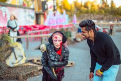 Kaksi ihmistä, toinen pukeutunut zombi-asuun Karmivan karnevaalin Zombie Zonella.