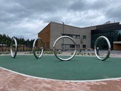 Pekka Jylhä (s. 1955): Peili, 2023. Ruostumaton teräs. Kuva: Miina Pohjolainen / Public Art Agency Finland. Peili koostuu neljästä heijastavasta ja halkaisijaltaan kolmemetrisestä metallisesta renkaasta, jotka tasapainottelevat leikkisästi pystyasennossa. Painottoman ja surrealistisen vaikutelman luoma Peili kutsuu keholliseen vuorovaikutukseen: myös veistoksen jalusta on pehmeää materiaalia turvallisuuden parantamiseksi.