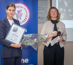 Voglian Katriina Virtanen vastaanottamassa Pukeutuminen & hyvinvointi -kategoriavoittajan palkintoa. Palkinnon luovutti kuvassa oikealla Vastuullisuuspaneelin puheenjohtaja Minna Halme.