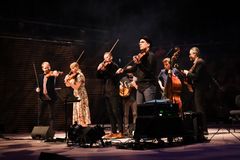 Muusikot esittämässä kansanmusiikkia konsertissa, jossa soitetaan viuluja ja kontrabassoa.