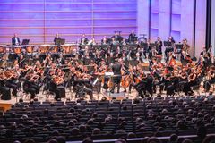 Sinfoniaorkesteri esiintyy konserttisalissa kapellimestarin johdolla.