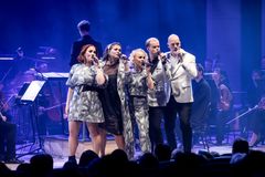 Lauluyhtye esiintyy orkesterin kanssa lavalla.