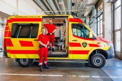 Ensihoitajat seisovat ambulanssin edessä.