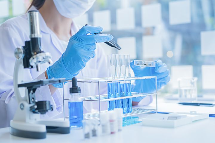 Suojavaatteisiin pukeutunut tutkija työskentelee laboratoriossa.