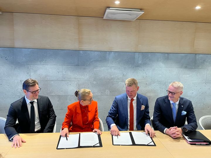 Enter Espoon toimitusjohtaja Jaana Tuomi ja Riihimäen kaupunginjohtaja Jouni Eho allekirjoittamassa sopimusta pöydän ääressä. Sivuilla kaksi henkilöä.