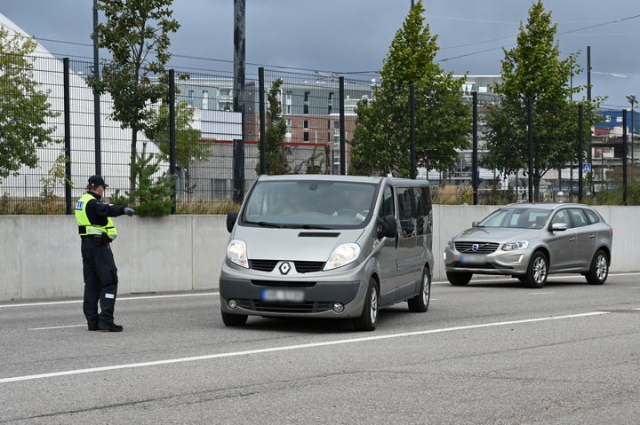 Tullin%20ty%F6ntekij%E4%20keltainen%20huomioliivi%20yll%E4%E4n%20ohjaa%20autoja.