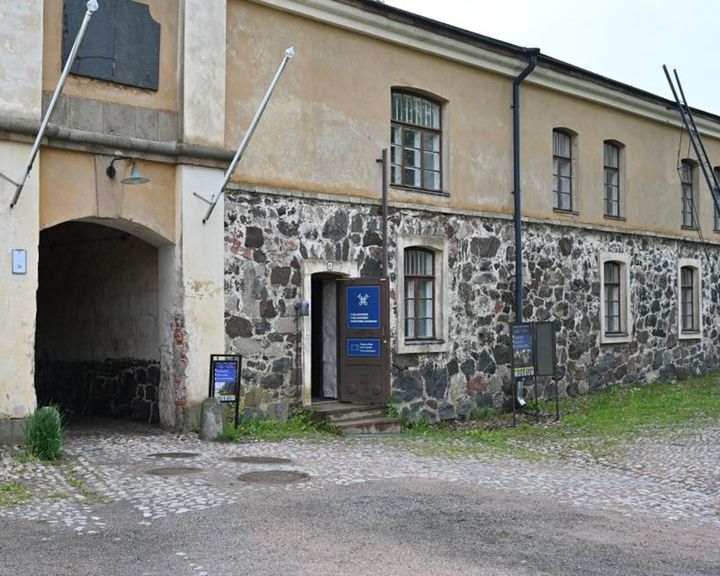 Kuva Tullimuseon sisäänkäynnistä. Rakennuksessa on kiviseinät ja harmaa katto.