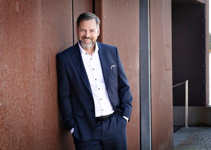 Kolsterin toimitusjohtaja Timo Helosuo nojaa seinään ja hymyilee.