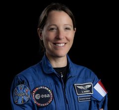Astronautti Sophien Adenot sinisessä ESA-haalarissa hymyilee.
